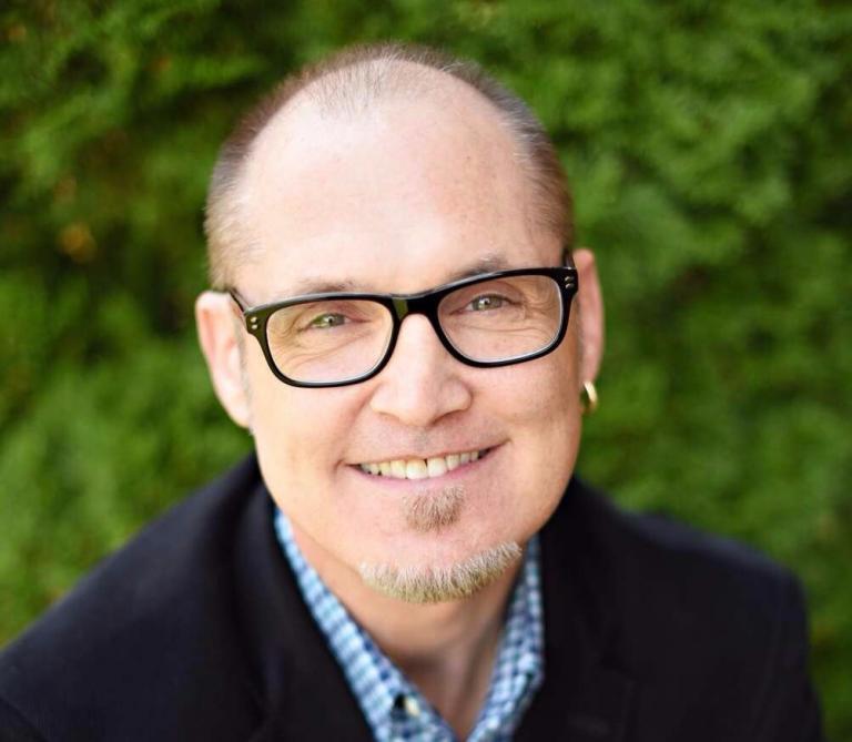 a man wearing glasses and a black jacket